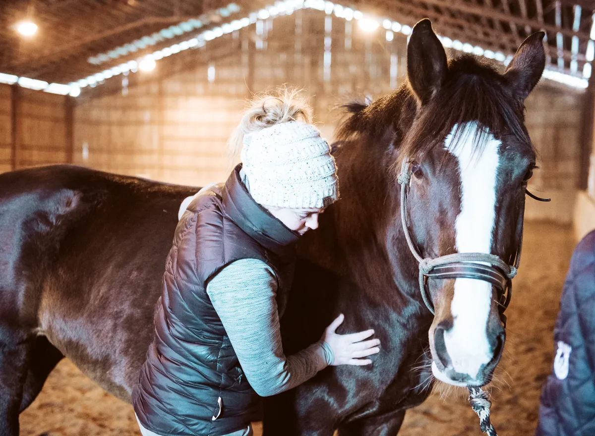 Erin Grace, equine massage therapist, treating a dark bay horse at her Smiths Falls area barn